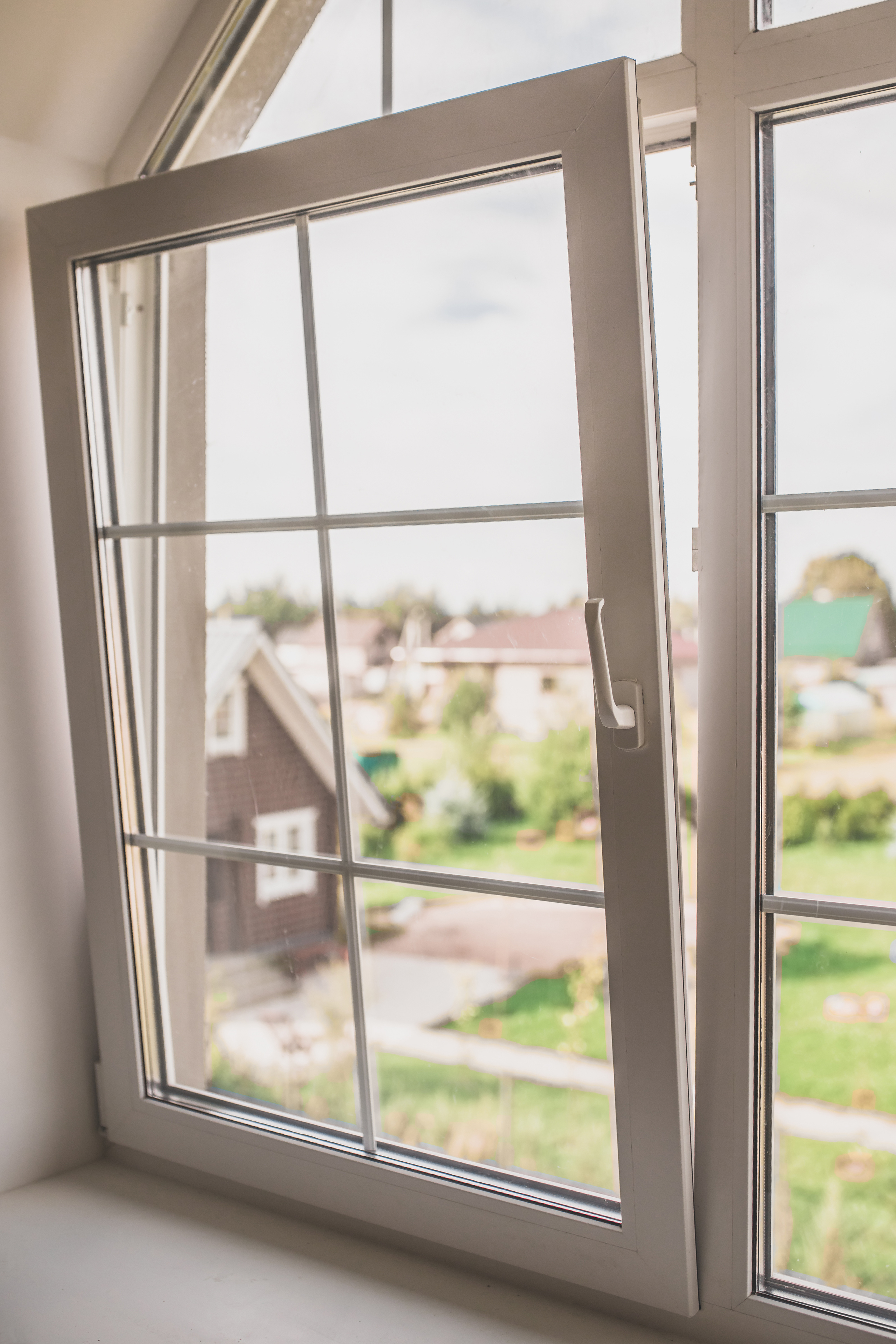 Plastic window in the window in the attic is partially open for ventilation